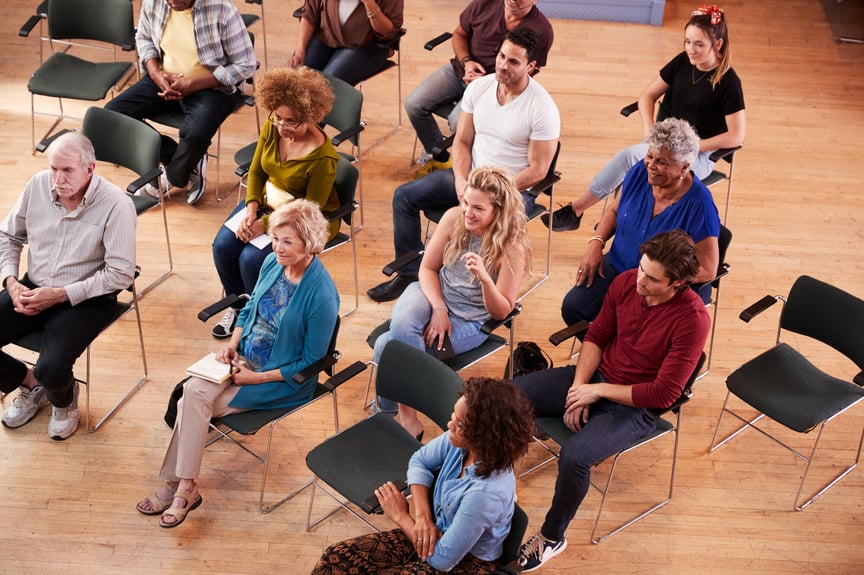 Overhead View Of Group Attending Neighborhood Meeting In Community Center